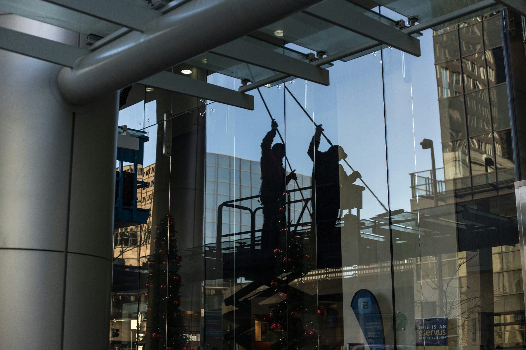 Two cleaners working on a commercial glass facade