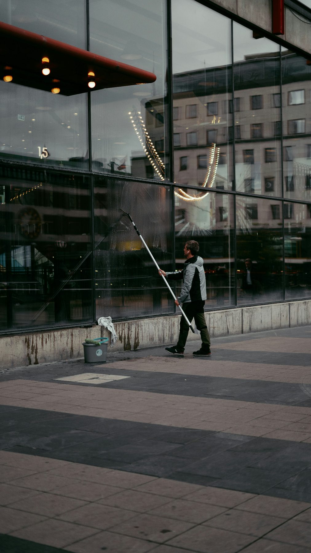 Professional cleaner washing a shopfront window