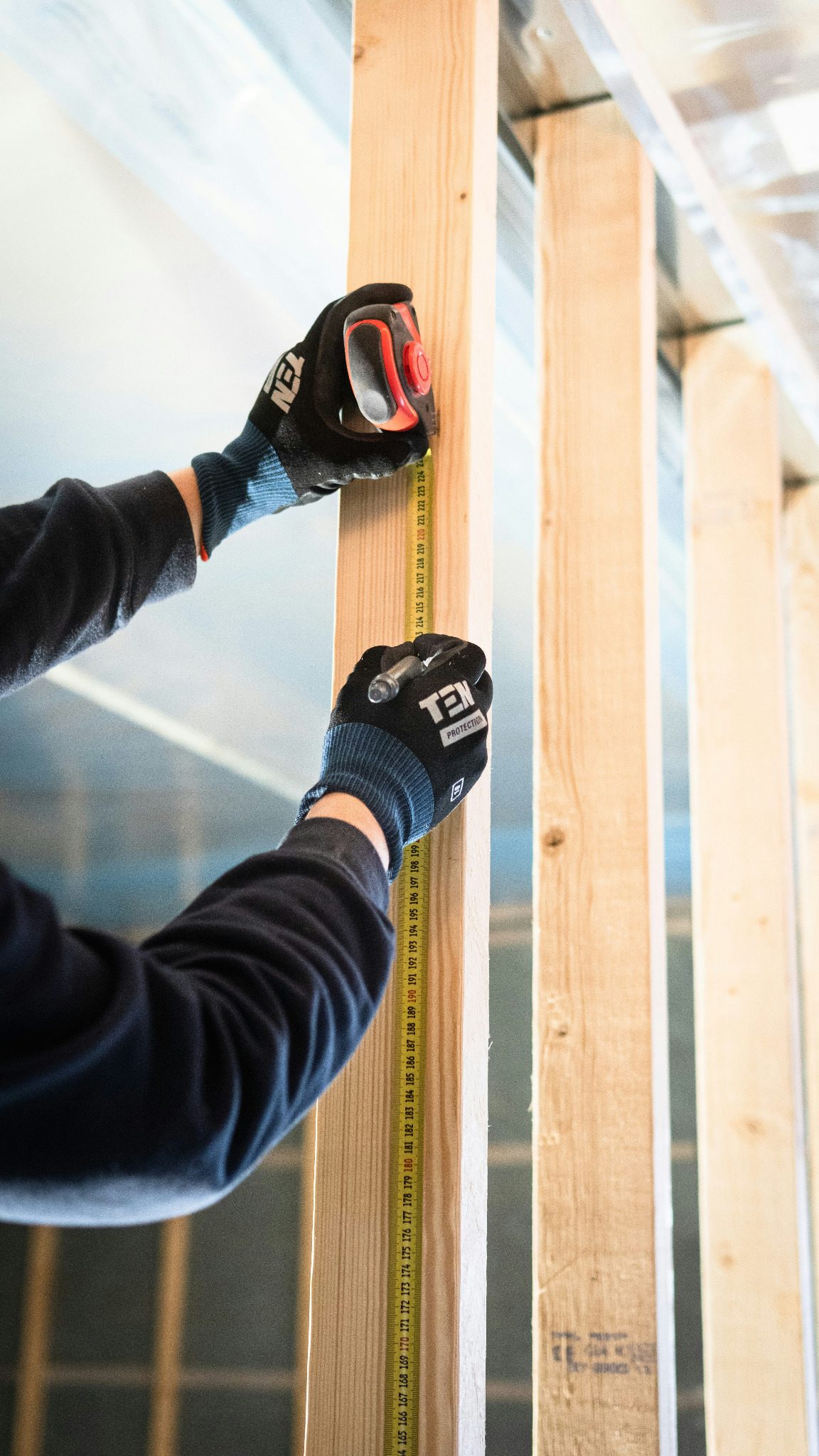 Carpenter measuring timber studs