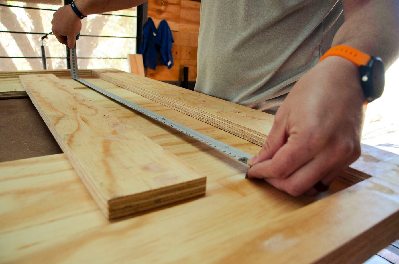 Carpenter measuring a timber board before cutting