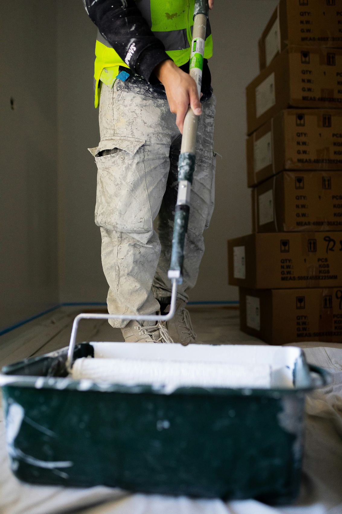 Painter using a roller and paint tray during an interior painting job