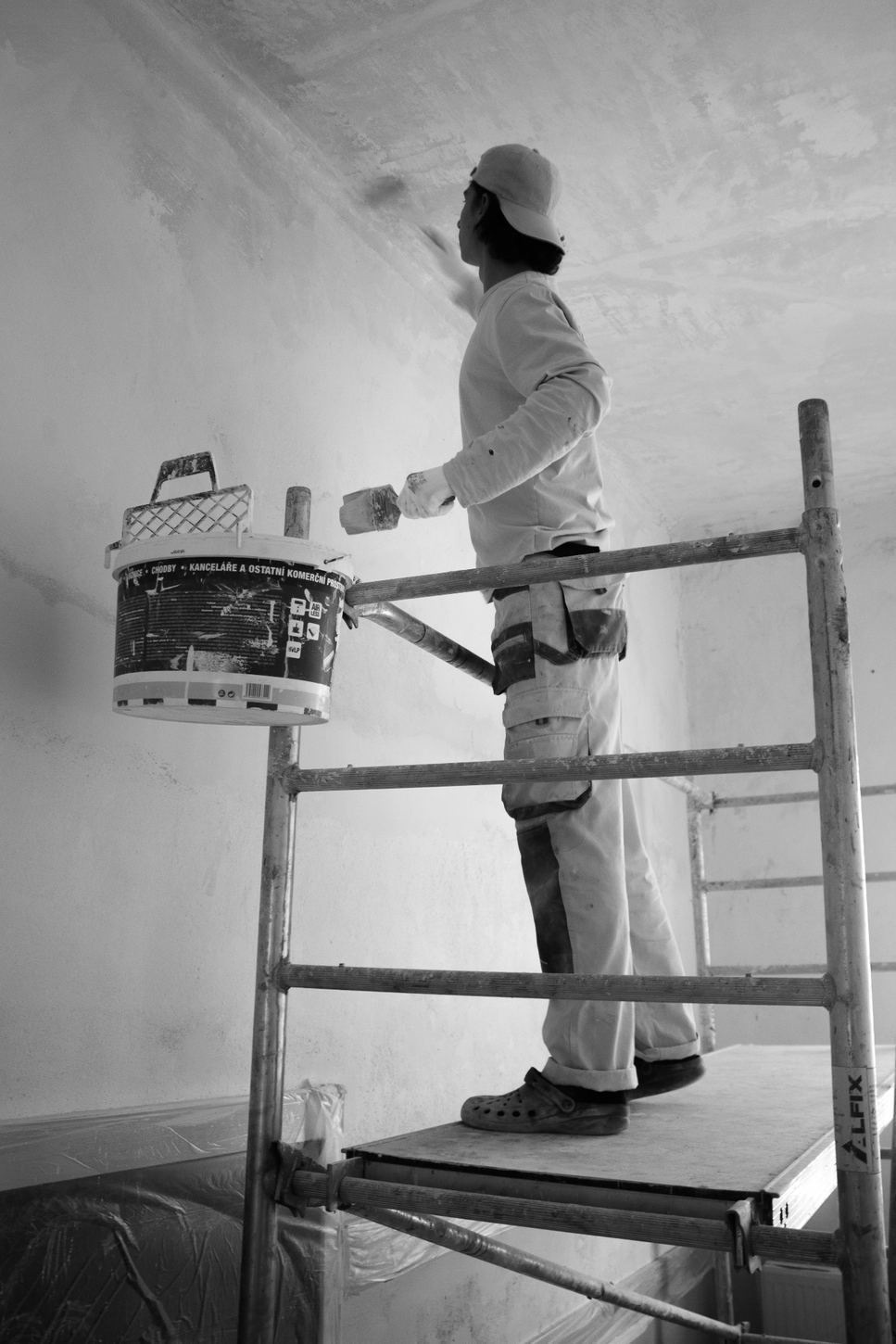 Painter preparing a wall from scaffolding before the final coat